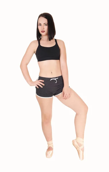 Dancing young woman standing tiptoe in shorts — Stock Photo, Image