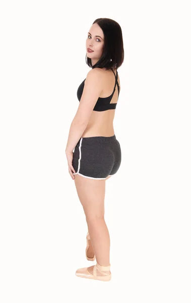 Jovem mulher de pé em shorts pretos no perfil — Fotografia de Stock