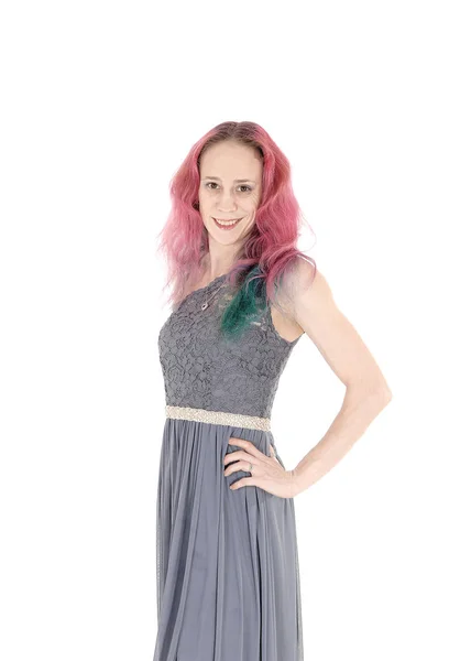 Young woman in a gray dress standing in profile and smiling — Stock Photo, Image