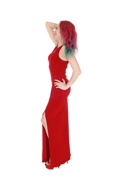 Slim woman standing in a red evening dress in the studio — Stock Photo, Image