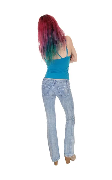 Slanke jonge vrouw staande terug in jeans — Stockfoto