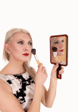 Güzel sarışın kadın makyajını düzeltiyor