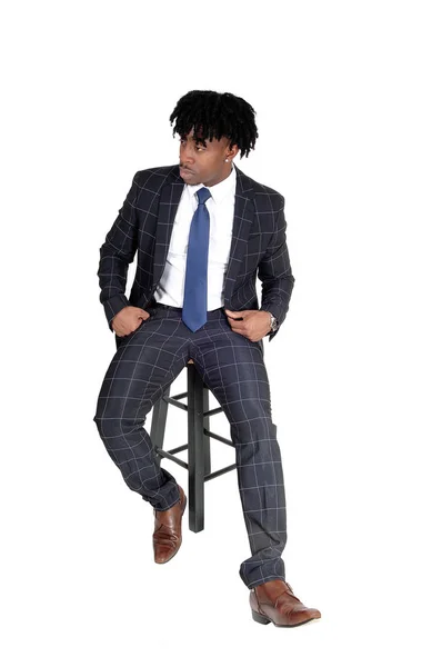 Młody dobrze wyglądający czarny człowiek siedzi na krześle — Zdjęcie stockowe