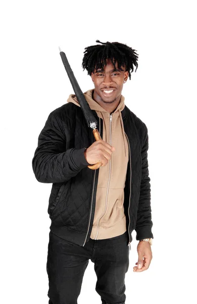 Black man standing in the studio with umbrella over his shoulder — Stock Photo, Image