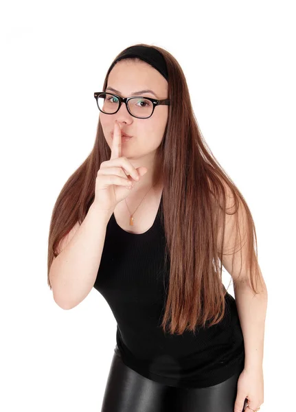 Härlig tonårs flicka stående med finger över munnar — Stockfoto