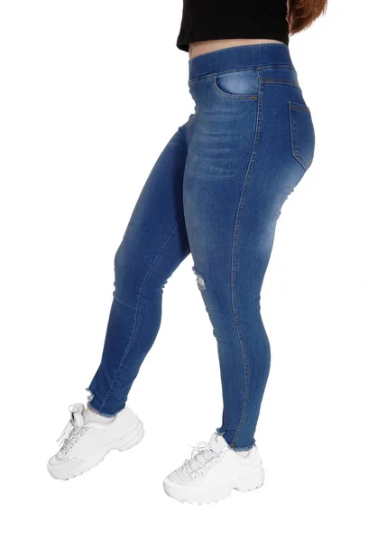 O fundo e as pernas de uma jovem em jeans — Fotografia de Stock