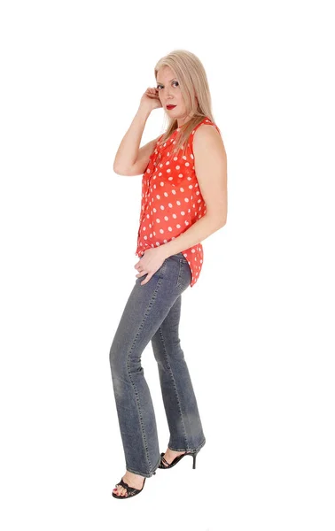 Middle age woman standing in profile in jeans — Stock Photo, Image