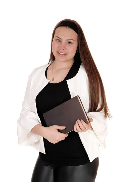 Tiener meisje staande witte jas houden van een boek in handen — Stockfoto
