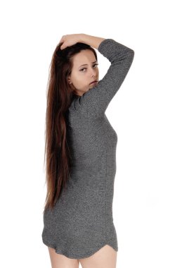 Gri bir elbise içinde duran güzel genç kadın