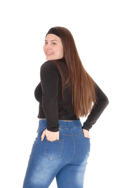 Девушка-подросток стоит сзади в джинсах — стоковое фото