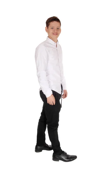 Egy fiatal tinédzser fiú áll fehér ingben. — Stock Fotó