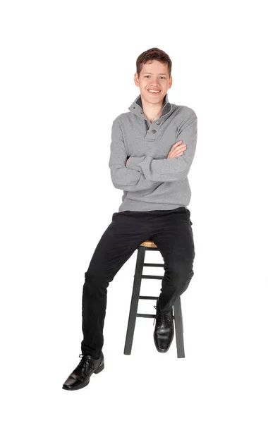 Krásný dospívající chlapec sedí a usmívá se — Stock fotografie