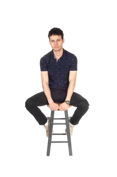 Красивый высокий молодой человек, сидящий на стуле в студии — стоковое фото