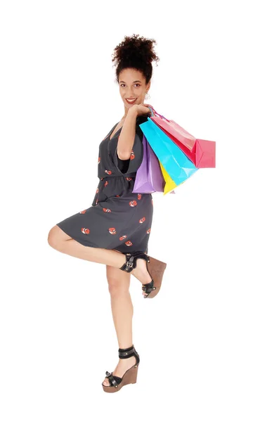 Joyeux jeune femme faisant du shopping avec les sacs par-dessus son épaule — Photo