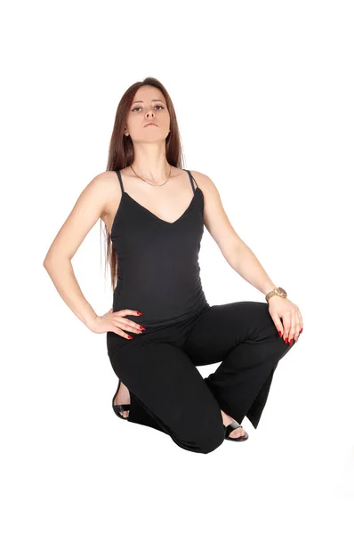 Lovely young woman crouching on the floor in black outfit — Stock Photo, Image