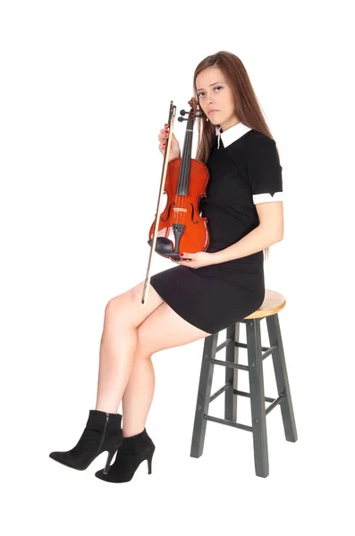 Uma mulher sentada e segurando seu violino, descansando — Fotografia de Stock