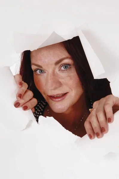 Woman looking through a hole in the paper — Stock Photo, Image