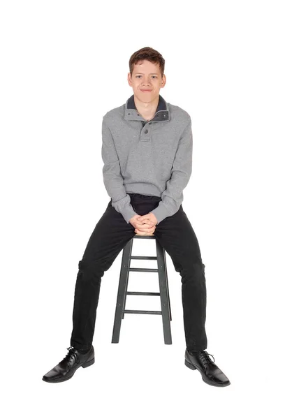 Um lindo menino adolescente adorável sentado e sorrindo — Fotografia de Stock