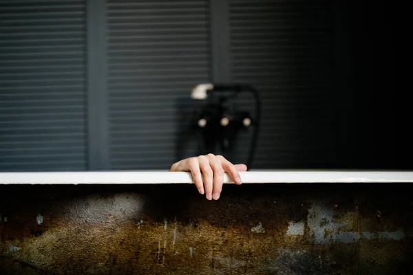 Mão feminina descansando no lado de uma banheira — Fotografia de Stock