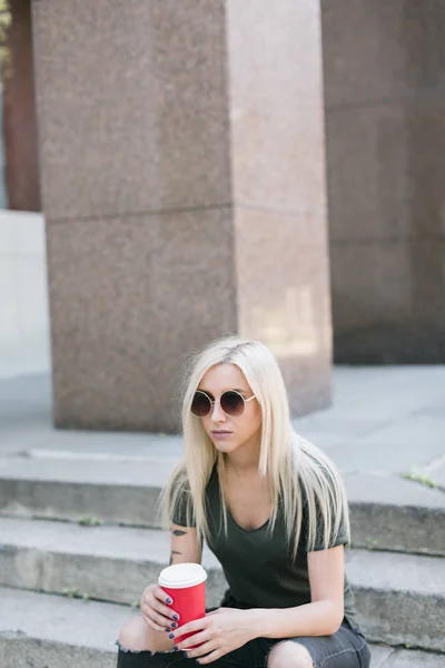 Blonde Frau trinkt Kaffee auf der Straße — Stockfoto