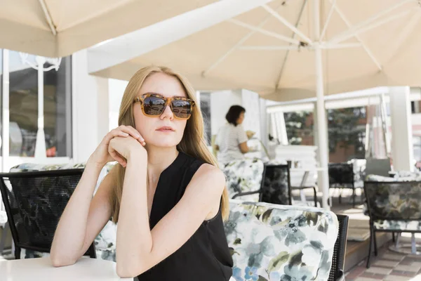 Porträt einer jungen Frau, die in einem Café sitzt. — Stockfoto