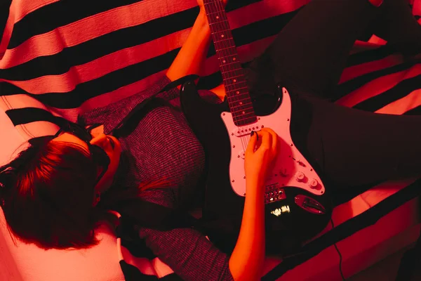 Young cool woman at home playing on guitar — Stockfoto