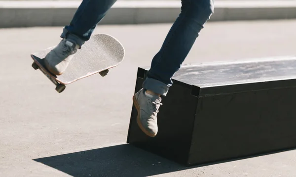 Jonge man doet truc op skateboard Stockafbeelding