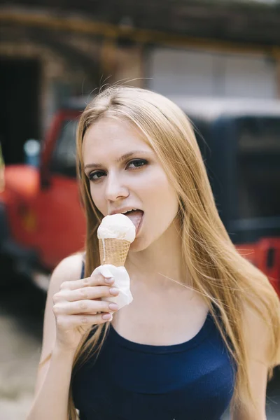 Mujer joven lamiendo un helado Imágenes De Stock Sin Royalties Gratis