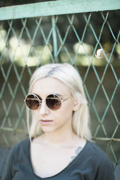 Cool ung kvinna med runda solglasögon Royaltyfria Stockfoton