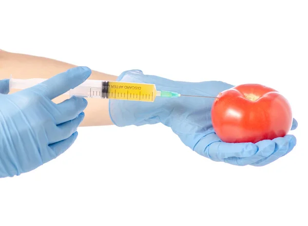 Syringe in de handen van tomaat — Stockfoto