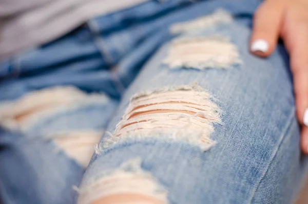 Woman in torn jeans macro