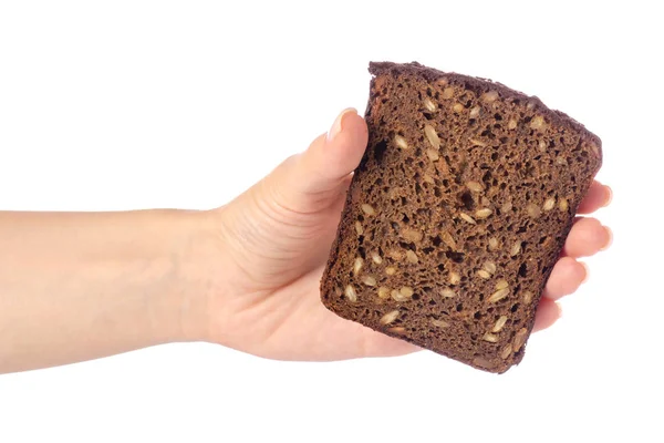 Um pedaço de pão com sementes em uma mão — Fotografia de Stock