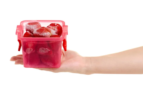 Frozen strawberries in a container in hand — Stock Photo, Image