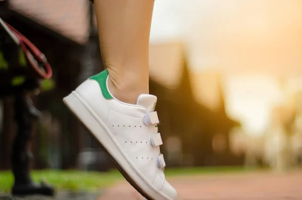 Female legs in street sneakers on blur background beauty fashion — Stock Photo, Image