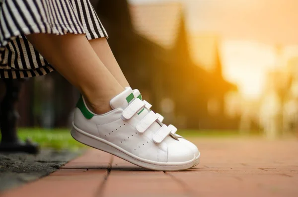 Female legs in street sneakers on blur background beauty fashion