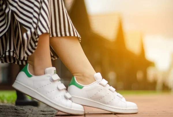 Female legs in street sneakers on blur background beauty fashion