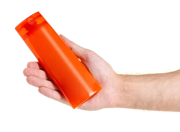 Botella naranja belleza champú gel de ducha en la mano —  Fotos de Stock