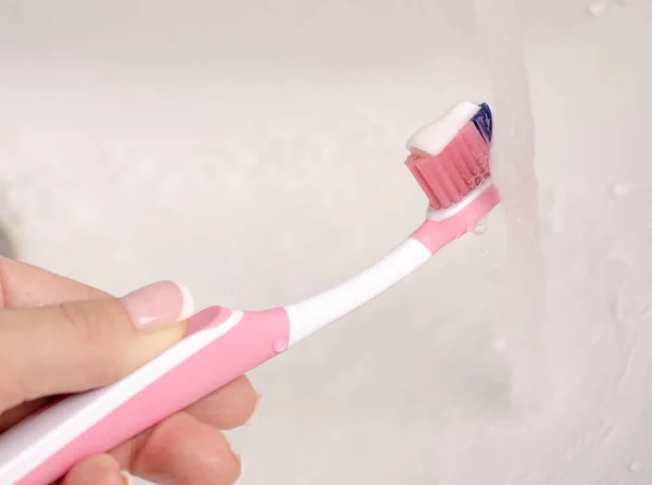 Toothbrush toothpaste in hand water — Stock Photo, Image