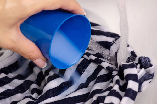 Lavar una mancha en la ropa bajo el agua acondicionador de manchas para tela — Foto de Stock
