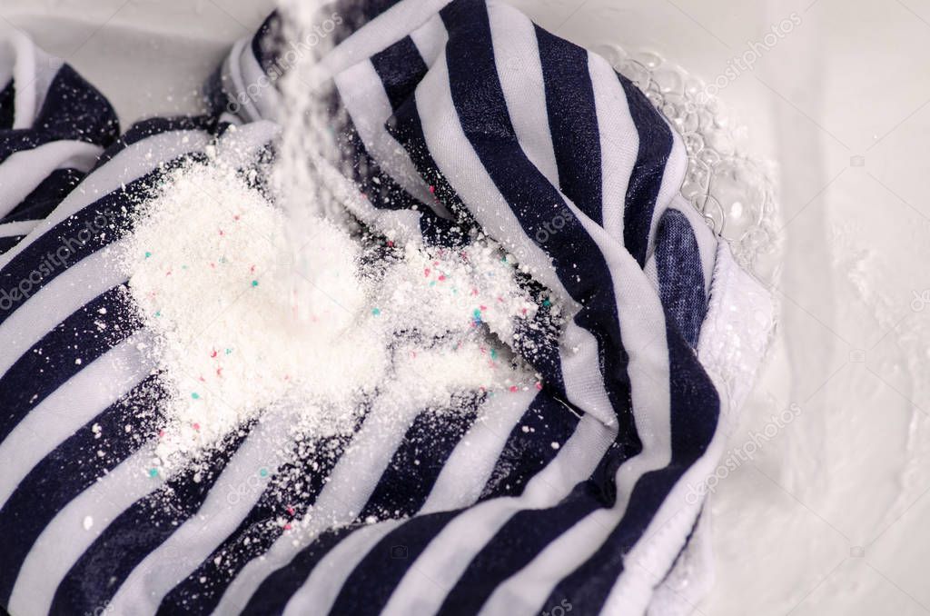 Wash a stain on white clothes under water stain powder for washing