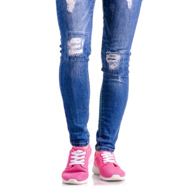 Kadının bacakları mavi kot pembe spor ayakkabı