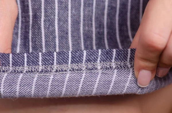 Mujer en vestido azul tela de costura rayada macro —  Fotos de Stock