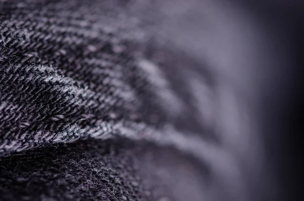Black denim fabric macro blur background