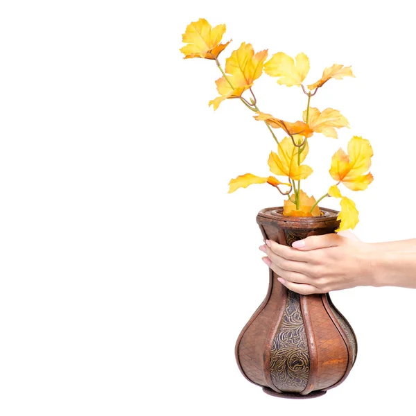 Wooden vase autumn leaves in hand