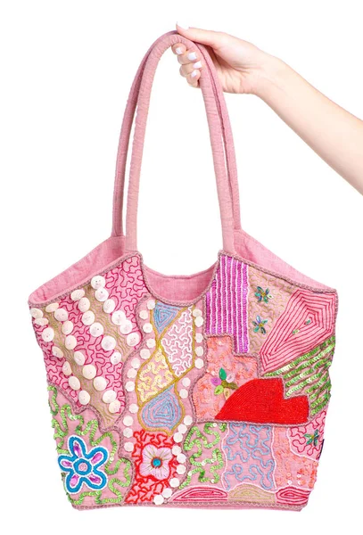 Rózsaszín női táska hímzés a kezében — Stock Fotó