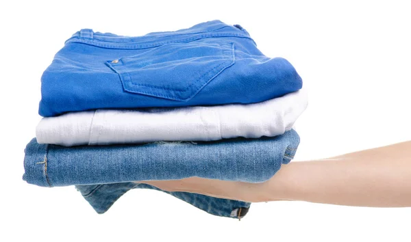 Een stapel van jeans kleding in de hand — Stockfoto