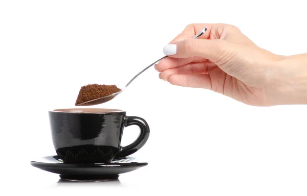 Schwarze Kaffeetasse und Untertasse Löffel in der Hand — Stockfoto