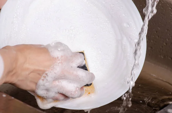 Esponja para lavar pratos prato em mãos — Fotografia de Stock
