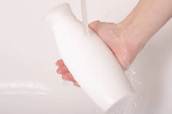 Gel mandi botol putih di tangan mandi air — Stok Foto