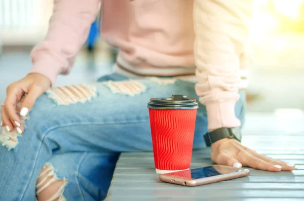 Mulher bonita em jeans e uma camisola com telefone celular smartphone café — Fotografia de Stock